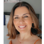 A wpman with light brown hair to her shoulders facing the camera smiling 