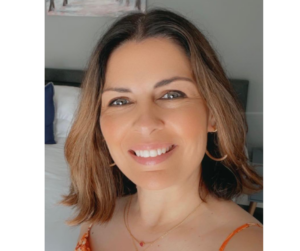 A wpman with light brown hair to her shoulders facing the camera smiling 